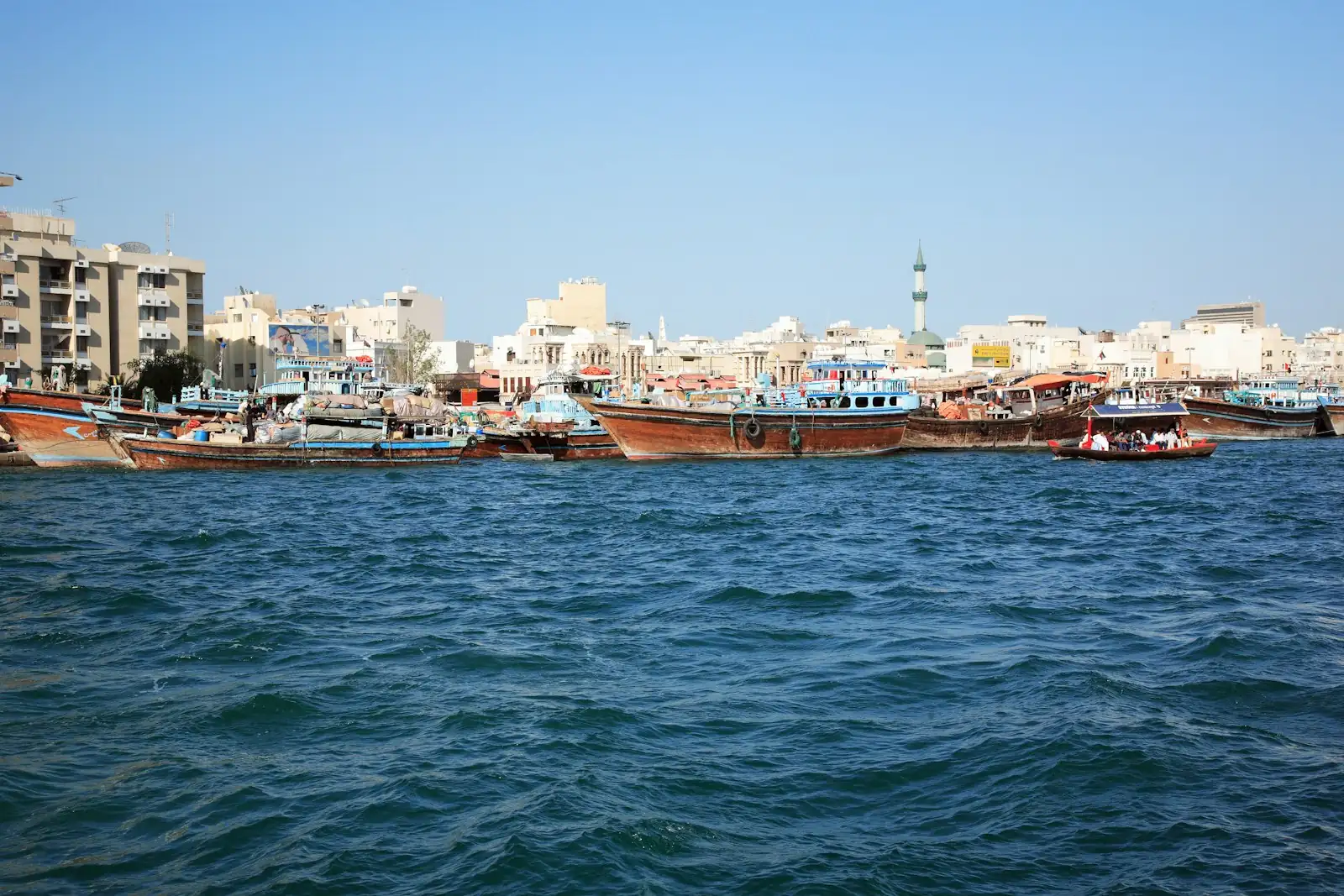 Dhows moored on Dubai Creek with Deira buildings behind