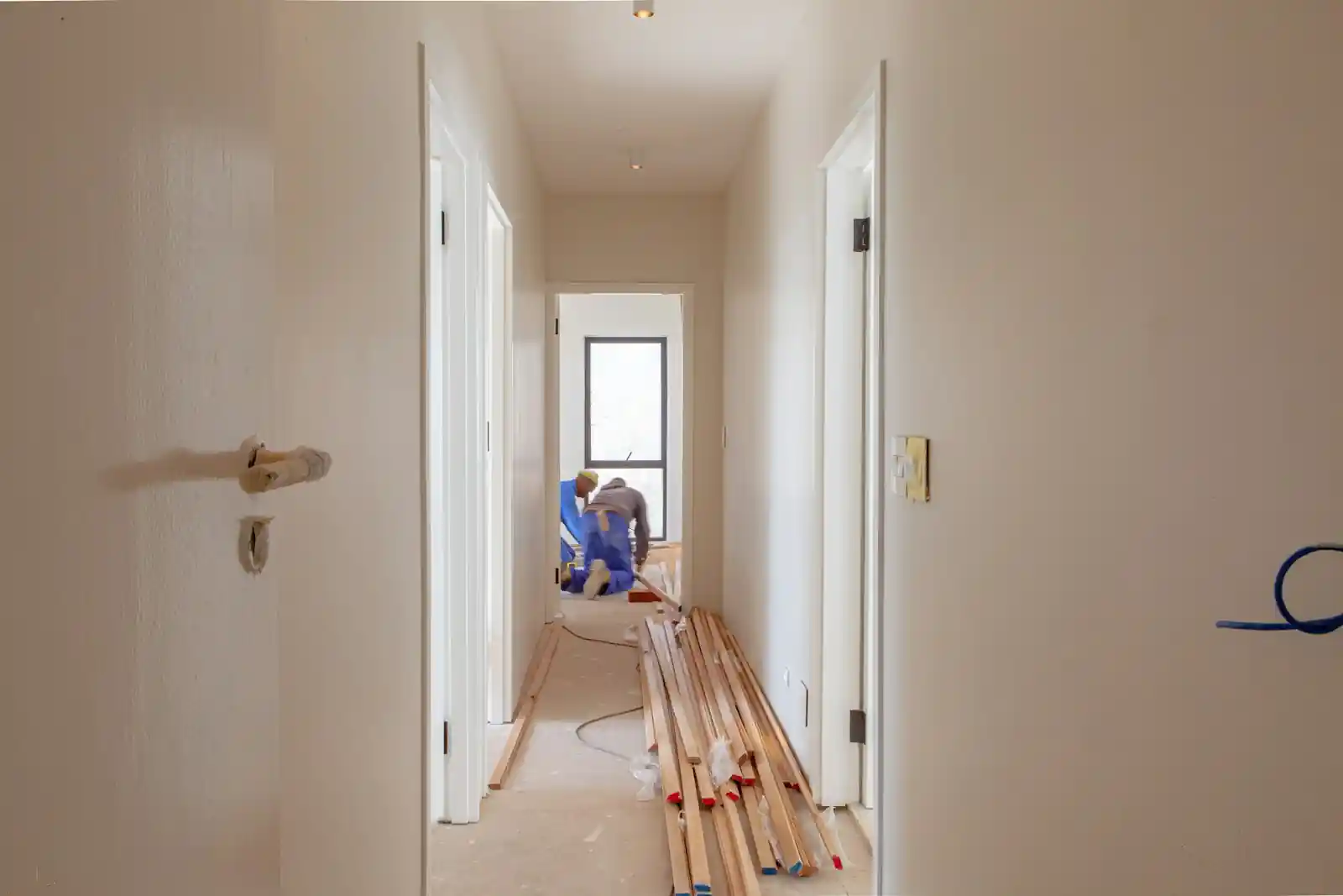 Apartment hallway during renovation with tools on the floor